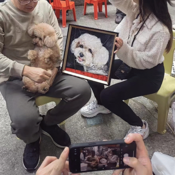 A couple receiving a cute expressionist portrait of their dog
